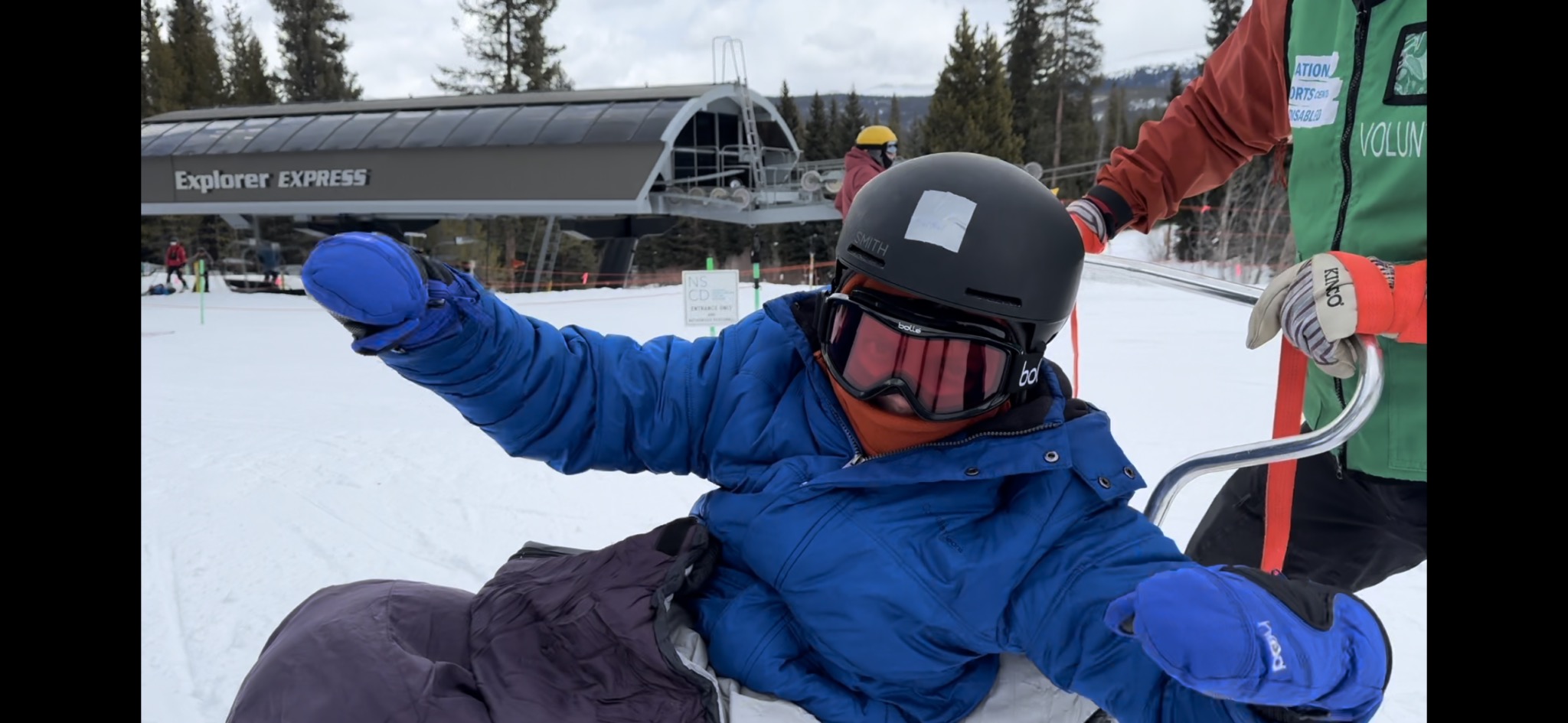 Child with EB enjoying adaptive skiing with the support of volunteers